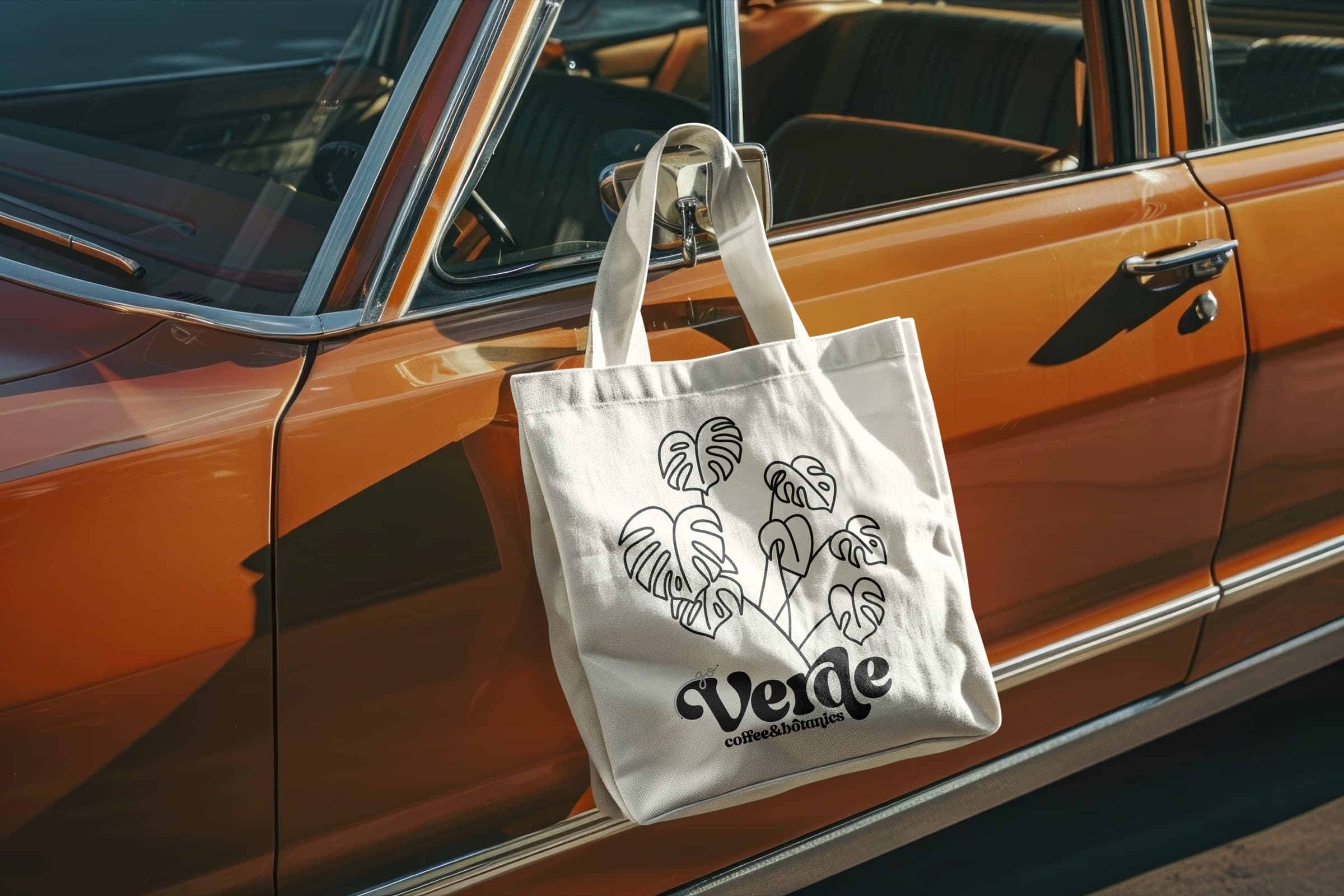 Verde monstera tote bag hanging from a vintage car mirror